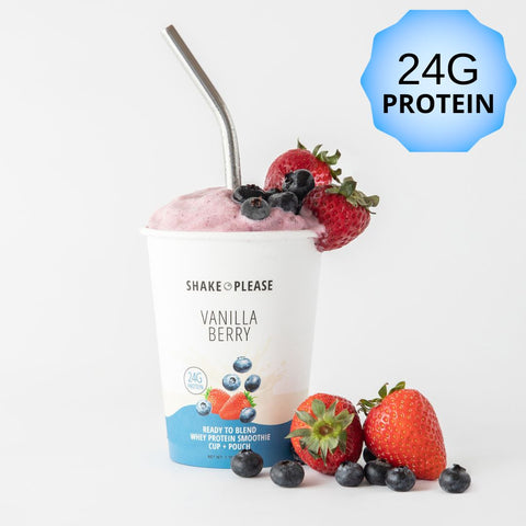 Premade vanilla berry protein smoothie in a white cup with a purple lid labeled 24g protein, surrounded by fresh strawberries and blueberries, ready to blend.